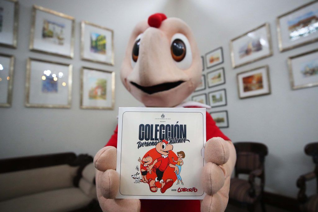 Mascota de Condorito sostiene el display Colección Personajes Chilenos de Casa de Moneda de Chile