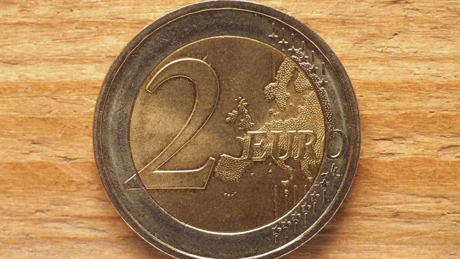 Primer plano de una moneda de 2 euros sobre una superficie de madera