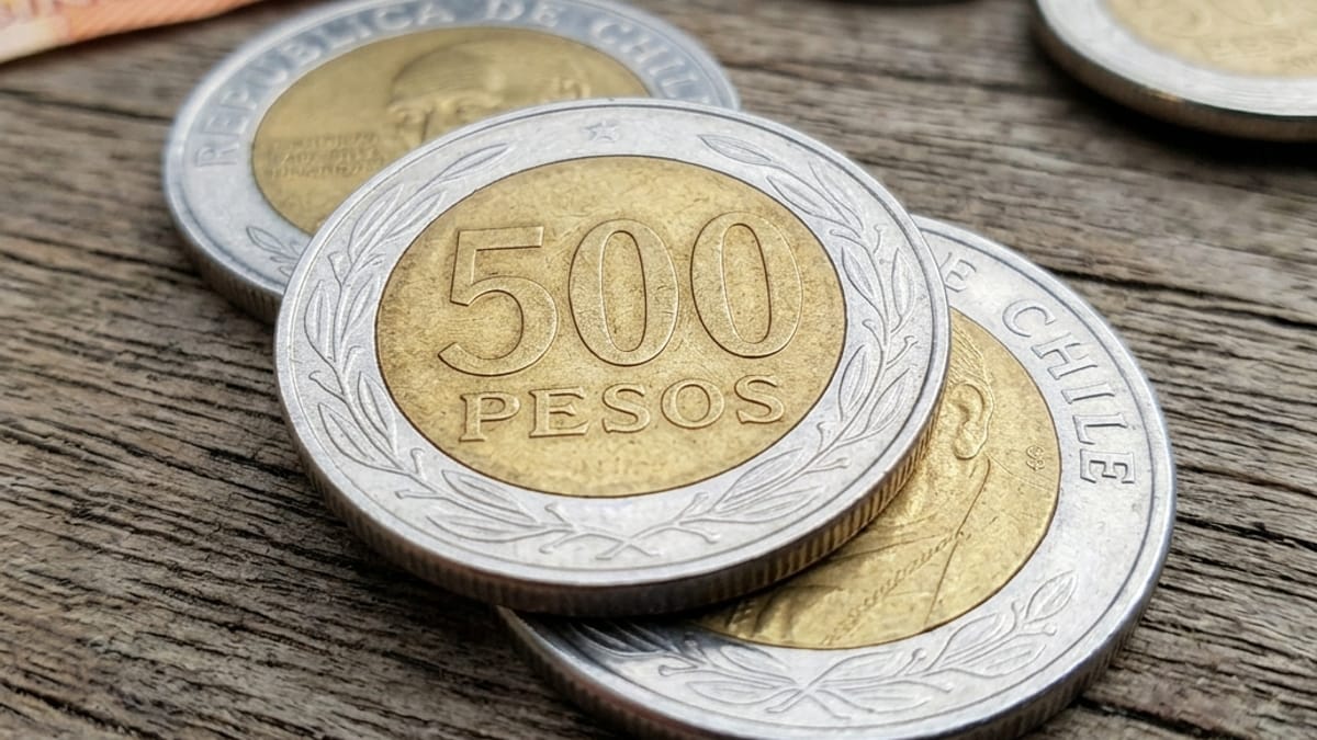 Monedas bimetálicas chilenas de 500 pesos sobre madera: reverso con el valor 500 y anverso con el retrato del cardenal