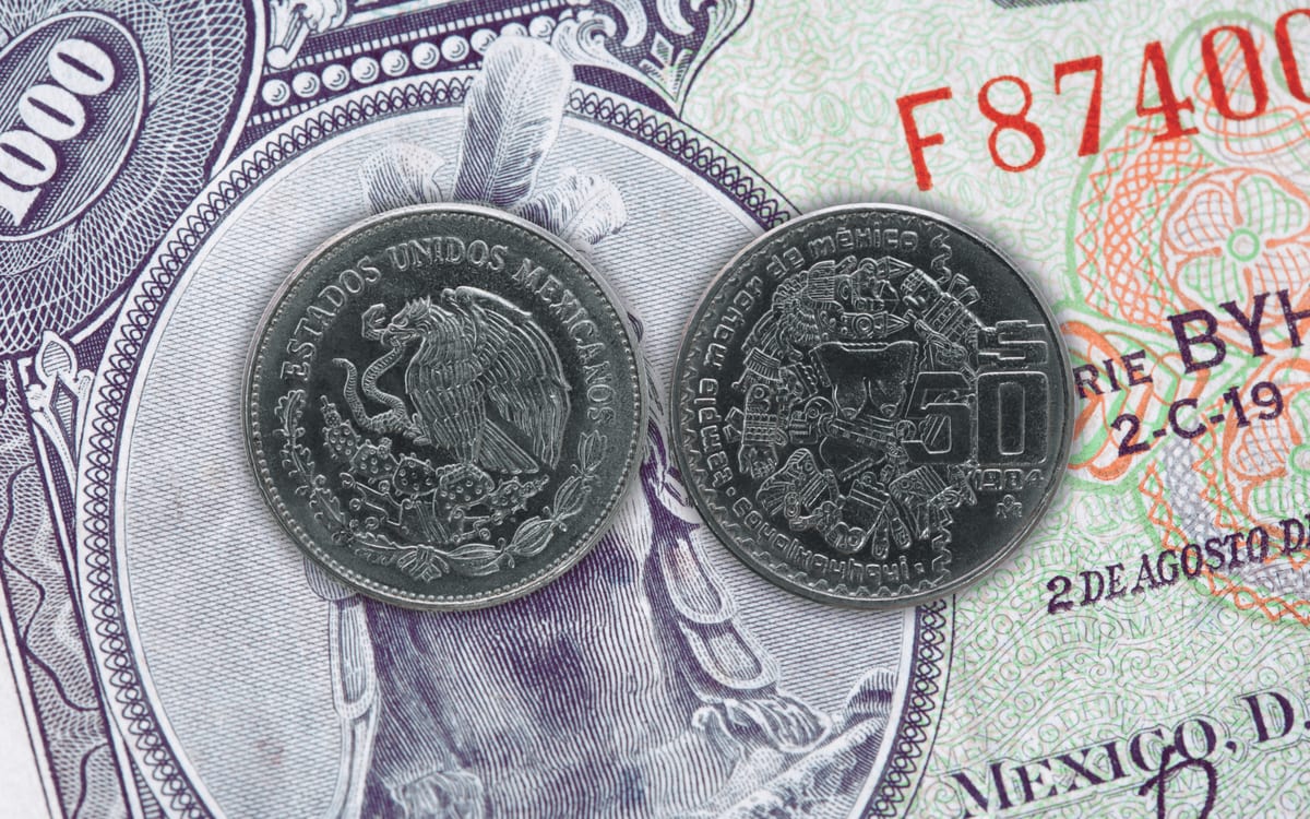 Dos monedas mexicanas de 50 pesos de 1984 con Coyolxauhqui sobre un billete antiguo de mil pesos